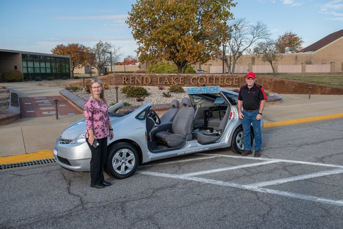 Kim Wilkerson (L), Rend Lake College Associate Vice President of CTE and Student Support, and Shannon Perkins (R), Rend Lake College Automotive Professor, with RLC'S hybrid trainer vehicle from Megatech.